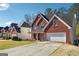 Suburban two-story brick home featuring a long driveway and an attached two-car garage at 992 Bay Pointe Sw Way, Lilburn, GA 30047