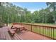 Expansive wooden deck with picnic table overlooks a lush, wooded backyard at 133 Harold Dr, Mcdonough, GA 30253