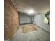 A basement with a gray door, bare concrete floor, and a brick accent wall at 360 Meadowbrook Dr, Mcdonough, GA 30253