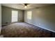 A neutral bedroom featuring plush carpet, two windows, and a ceiling fan at 360 Meadowbrook Dr, Mcdonough, GA 30253