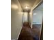 Clean hallway with neutral walls and carpet leading to various rooms, illuminated by overhead lighting at 360 Meadowbrook Dr, Mcdonough, GA 30253