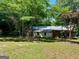 Exterior view of home with mature trees in a spacious green yard, showcasing serene natural surroundings at 360 Meadowbrook Dr, Mcdonough, GA 30253