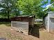 Exterior of shed shows corrugated metal walls and roof with overgrown yard at 360 Meadowbrook Dr, Mcdonough, GA 30253