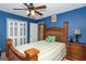 Primary bedroom with wood furnishings, blue accent wall, and ceiling fan at 3435 Pierce Arrow Cir, Suwanee, GA 30024