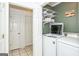 Convenient laundry room featuring a white washer and dryer with shelving at 3435 Pierce Arrow Cir, Suwanee, GA 30024
