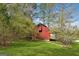 Red barn or outbuilding surrounded by greenery, set in a spacious yard at 2200 Gleneagle Nw Ct, Conyers, GA 30012