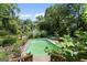 Overhead view of the backyard featuring a pool, deck, lush landscaping, and outbuildings at 2612 New Haven Dr, Jonesboro, GA 30236