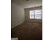 Bedroom featuring neutral carpet, a window with blinds, and ample natural light at 6342 Kinsland Ct, Lithonia, GA 30058