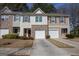 Charming townhome showcasing varied exterior finishes and attached garages with paved driveways at 6342 Kinsland Ct, Lithonia, GA 30058