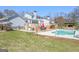 Backyard view featuring a pool, wooden deck with dining area, bar, and well-maintained lawn at 8 Cameron St, Moreland, GA 30259