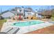 Inviting backyard with a refreshing pool, outdoor dining area, and lush green lawn perfect for relaxation at 8 Cameron St, Moreland, GA 30259