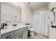 Well-lit bathroom with a marble vanity, framed mirror, and a shower-tub combination at 2441 Noelle Ln, Powder Springs, GA 30127