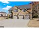 Traditional brick home with a three-car garage and a well-manicured front lawn on a sunny day at 2441 Noelle Ln, Powder Springs, GA 30127