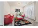 Cozy living room with a red leather sofa, modern rug, and sheer curtains for a bright atmosphere at 2441 Noelle Ln, Powder Springs, GA 30127