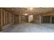 Unfinished basement featuring open layout, concrete floor, and exposed wooden framing with stair access at 336 Traditions Ln # 147, Hampton, GA 30228