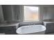 Bright bathroom with gray cabinets, double vanity, and large soaking tub at 336 Traditions Ln # 147, Hampton, GA 30228