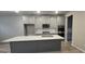 Island kitchen featuring gray cabinetry, stainless steel appliances and modern fixtures, with light countertops at 336 Traditions Ln # 147, Hampton, GA 30228