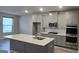 Modern kitchen features an island, stainless steel appliances, and gray cabinetry at 336 Traditions Ln # 147, Hampton, GA 30228