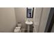 Cozy powder room featuring a pedestal sink and toilet at 336 Traditions Ln # 147, Hampton, GA 30228