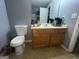 Bathroom featuring a commode and vanity with a wood cabinet, sink, faucet, and mirror at 2976 Vining Ridge Ln, Decatur, GA 30034