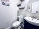 Stylish powder room featuring modern sink, toilet, decorative wall art and floating shelves, enhancing a compact yet chic design at 4436 Old Country Way, Snellville, GA 30039