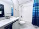 Bright bathroom with white vanity, toilet, and tub/shower with a blue shower curtain at 4436 Old Country Way, Snellville, GA 30039