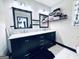 Bathroom vanity features dual sinks, a marble countertop, and black framed mirrors and shelving at 4436 Old Country Way, Snellville, GA 30039