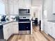 Bright kitchen features stainless steel appliances, including a sleek microwave and oven, complemented by ample white cabinetry at 4436 Old Country Way, Snellville, GA 30039