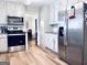 Bright kitchen features stainless steel appliances, including a sleek microwave and oven, complemented by ample white cabinetry at 4436 Old Country Way, Snellville, GA 30039