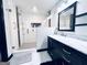 Modern shower features glass enclosure, white tiled walls, and dual shower heads next to updated vanity at 4436 Old Country Way, Snellville, GA 30039