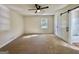 Bedroom with carpet, ceiling fan, and barn door leading to a bathroom with natural light at 3280 Gum Creek Rd, Oxford, GA 30054