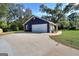 Side view of a home with a two-car garage and a long driveway on a sunny day at 3280 Gum Creek Rd, Oxford, GA 30054