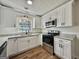 Bright kitchen with white cabinets, granite countertops, and modern appliances at 3280 Gum Creek Rd, Oxford, GA 30054