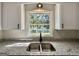 Close-up of kitchen sink with granite countertops and a backyard view at 3280 Gum Creek Rd, Oxford, GA 30054