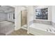 Beautiful bathroom featuring walk-in shower, a soaking tub, and large window at 3725 Heron Creek Ct, Loganville, GA 30052