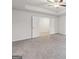 A brightly lit bedroom with plush carpet features a tray ceiling and double doors at 3725 Heron Creek Ct, Loganville, GA 30052