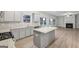 Open-plan kitchen with gray cabinets, granite countertops, stainless steel appliances, and hardwood flooring at 3725 Heron Creek Ct, Loganville, GA 30052