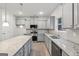 Modern kitchen with gray cabinets, granite countertops, stainless steel appliances, and a kitchen island at 3725 Heron Creek Ct, Loganville, GA 30052