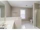 Bright bathroom featuring white tiled floors, a window, and a separate shower stall at 5105 Cascade Hills Cir, Atlanta, GA 30331