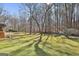 Spacious backyard with tall trees, lush greenery and a wooden deck at 208 Pinnacle Ct, Peachtree City, GA 30269