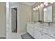 Bathroom featuring double vanity with bright lighting, mirrors, and tiled flooring at 208 Pinnacle Ct, Peachtree City, GA 30269