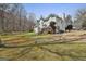 Rear view of a two-story home with a spacious yard and a wooden deck at 208 Pinnacle Ct, Peachtree City, GA 30269