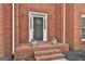 Inviting front entrance with a brick porch, decorative wreath, and charming flower pots at 208 Pinnacle Ct, Peachtree City, GA 30269