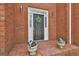 Charming entryway features a decorative wreath, potted plants, and elegant exterior lighting at 208 Pinnacle Ct, Peachtree City, GA 30269