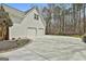 Spacious three-car garage with a long driveway, set against a backdrop of lush trees at 208 Pinnacle Ct, Peachtree City, GA 30269