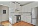 Bright kitchen features stainless steel appliances, white cabinets, and hardwood flooring at 208 Pinnacle Ct, Peachtree City, GA 30269