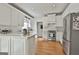 Bright kitchen boasts white cabinets, stainless steel appliances, and hardwood flooring at 208 Pinnacle Ct, Peachtree City, GA 30269