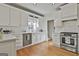 Bright kitchen boasts white cabinets, stainless steel appliances, and hardwood flooring at 208 Pinnacle Ct, Peachtree City, GA 30269