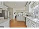 Well-lit kitchen with stainless steel appliances, white cabinets, and large sink at 208 Pinnacle Ct, Peachtree City, GA 30269