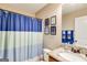 Bathroom featuring blue and white shower curtain, neutral paint, framed artwork and granite countertop at 305 Cranmore Pl, Villa Rica, GA 30180